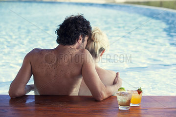 Couple relaxing together in pool  rear view