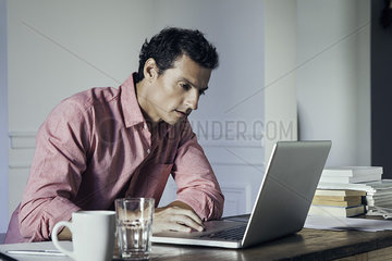 Man working on laptop computer at home