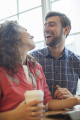 Couple laughing together in coffee shop