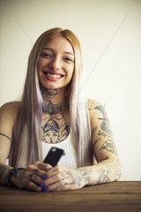 Tattooed woman using smartphone  portrait
