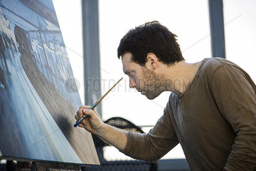 Artist working on oil painting in art studio