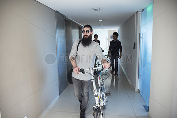 Man walking in corridor with bicycle