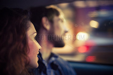 Couple looking out car window at night