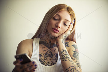 Tattooed woman using smartphone