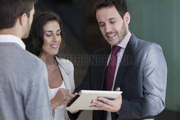 Business associates looking at proposal on digital tablet together