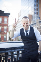Businessman making a peace sign gesture  smiling cheerfully  portrait