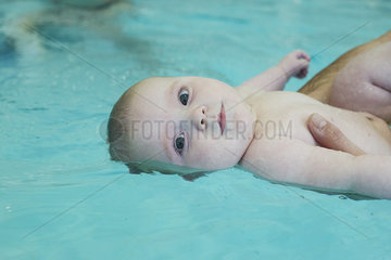 Infant held at water's surface