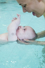 Mother and infant playing in pool