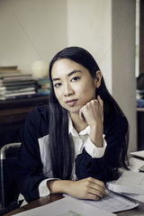Woman sitting at desk in office  portrait