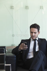 Executive looking at cell phone with concerned look