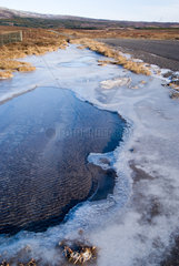 Island  Schmelzwasser umgeben von Eis an einer Landstrasse