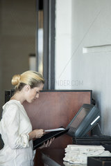 Waitress using computerized cash register in restaurant