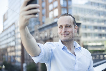 Man using cell phone to take a selfie