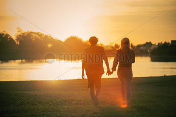 Couple walking hand in hand at water's edge