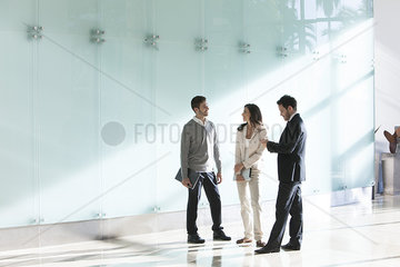 Business associates chatting in office corridor