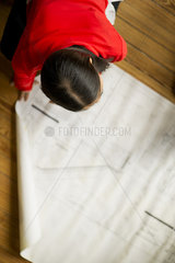 Female architect looking at blueprint