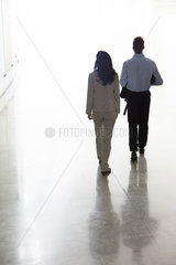 Business colleagues walking together in office corridor