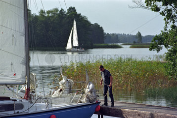 Ein Mann bei einem Segelboot in Trakai  Litauen