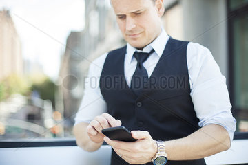Businessman text messaging with smartphone