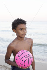 Boy playing volleyball on beach