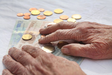 Berlin  Deutschland  die Haende einer Rentnerin liegen auf Geld