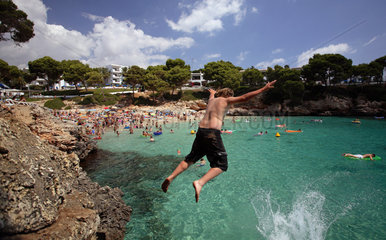 Cala D'Or  Jugendlicher springt von einem Felsen ins Wasser