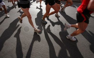 Berlin  Deutschland  Laeufer beim Marathon werfen ihre Schatten auf die Strasse