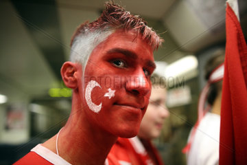 Berlin  Deutschland  tuerkischer Fussballfan mit Gesichtsbemalung in Nationalfarben