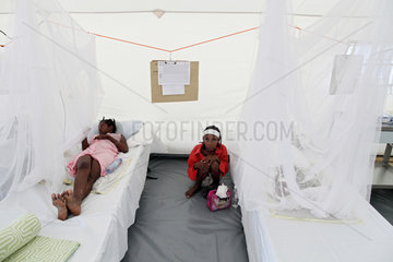 Carrefour  Haiti  eine junge Mutter hockt neben dem Bett ihres Kindes im Ambulanzzelt