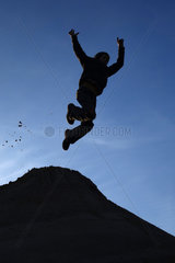 Schependorf  Deutschland  Silhouette  ein Junge macht einen Luftsprung