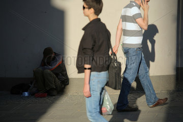Posen  Polen  Passanten laufen an einem obdachlosen Mann vorbei