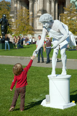 Berlin  Deutschland  ein Schausteller gibt einem Kind die Hand