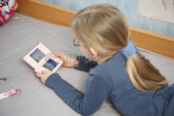 Hamburg  Deutschland  ein Maedchen spielt in ihrem Kinderzimmer Nintendo DS