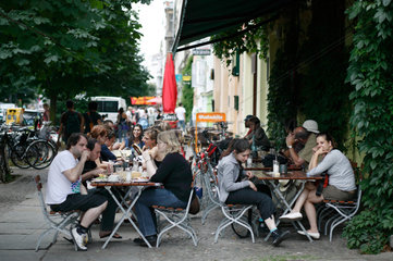 Berlin  Deutschland  Gaeste sitzen in einem Strassencafe in der Kastanienallee