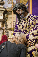 Sevilla  Spanien  Frau kuesst die Hand von Jesus del Gran Poder