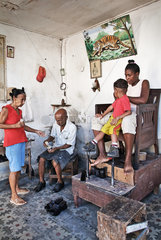 Santiago de Cuba  Kuba  Kunden bei einem Schuhputzer