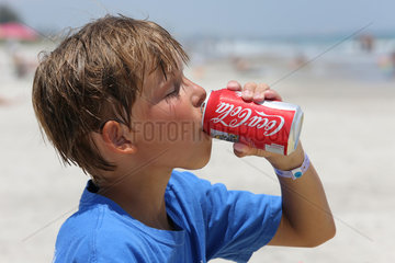 Cocoa Beach  USA  Junge trinkt Coca Cola aus einer Dose