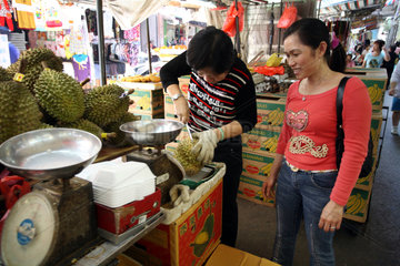 Macau  China  Frau prueft Durian-Fruechte an einem Marktstand