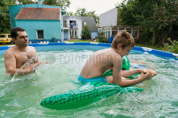 Breslau  Polen  Familie planscht im Wasser im aufblasbares Pool im Garten