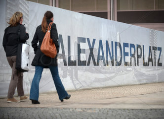 Berlin  Deutschland  Passanten laufen an einem Bauzaun am Alexanderplatz vorbei