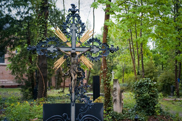 Berlin  Deutschland  Grabkreuz mit Jesusfigur auf dem alten Domfriedhof der St. Hedwigsgemeinde