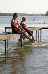 Ploen  Deutschland  eine junge Frau entspannt mit ihrem Sohn auf einem Bootssteg