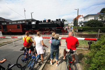 Kuehlungsborn  Deutschland  Menschen warten an einer Eisenbahnschranke