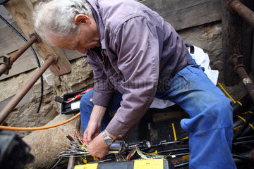 Berlin  Deutschland  Fernmeldehandwerker montiert eine Steuerung