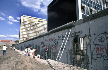 Berlin nach Maueroeffnung - Mauerspechte tragen die Mauer ab