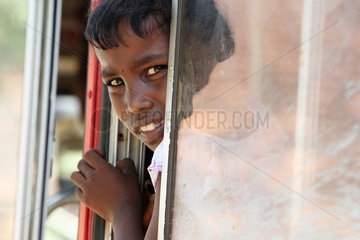 Batticaloa  Sri Lanka  Maedchen schaut aengstlich aus einem Bus