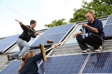 Berlin  Deutschland  Auszubildende putzt ein Solarpanel