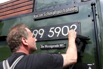 Wernigerode  Deutschland  ein Lokfuehrer putzt die Kennnummer einer Malletlok