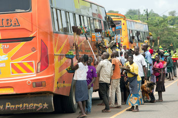 Kamdini  Uganda - An einem Busstop bieten Fliegende Haendler Reisenden eines Ueberlandbusses Waren zum Verkauf an.