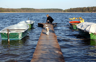 Lindow  Deutschland  eine Frau mit ihrem Hund auf einem Steg am Wutzsee